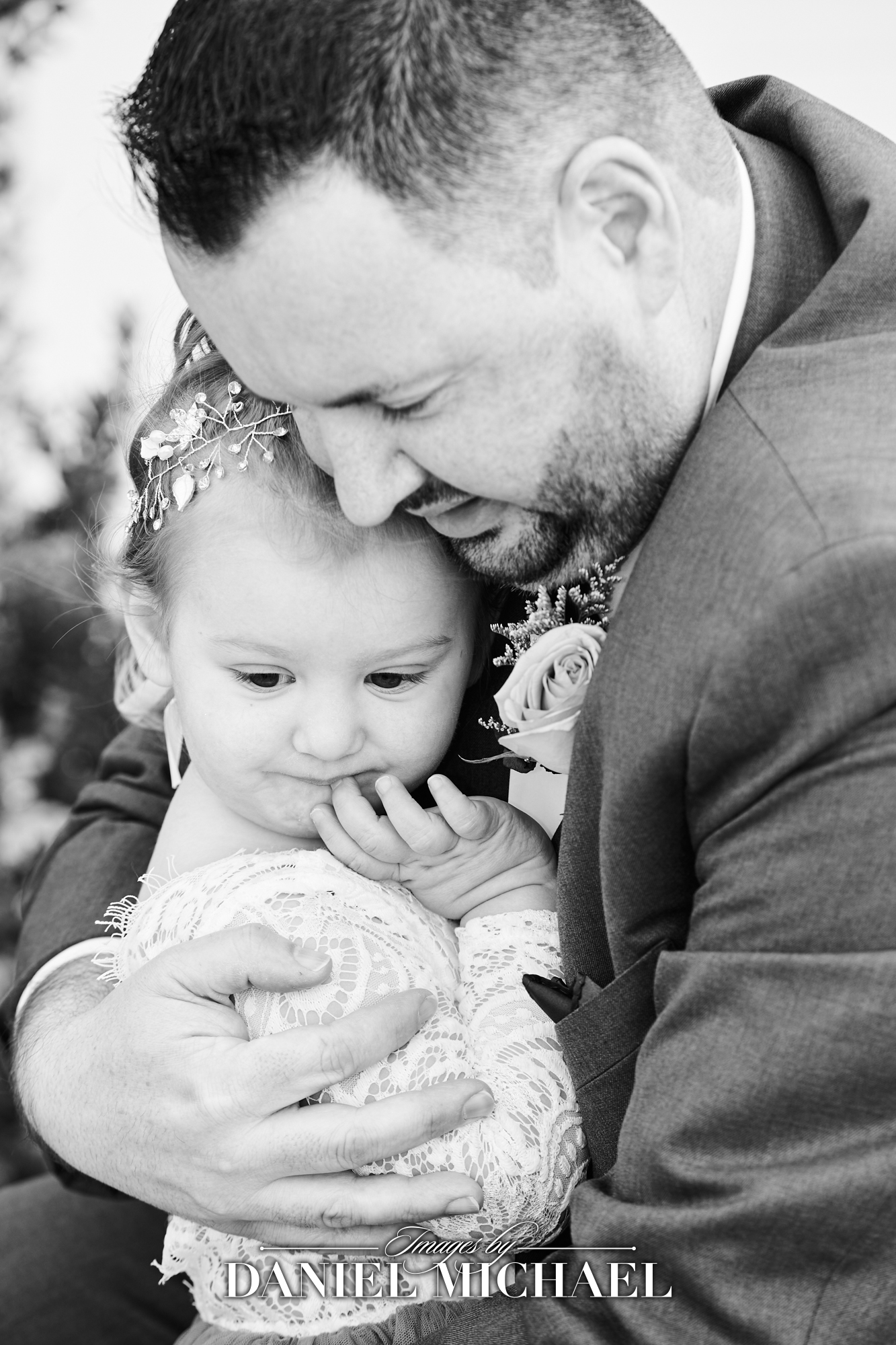 Groom sharing emotional moment with his young daugher